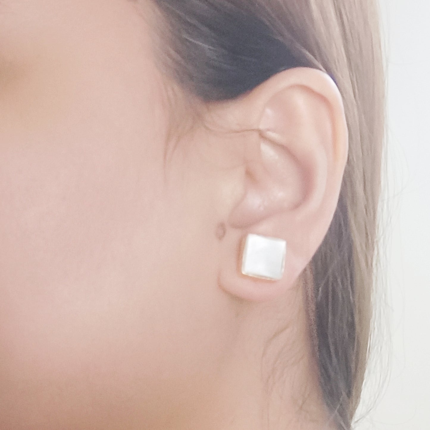 Model wearing Mother of Pearl stud earrings – luminous white shell jewelry by Gemsara.