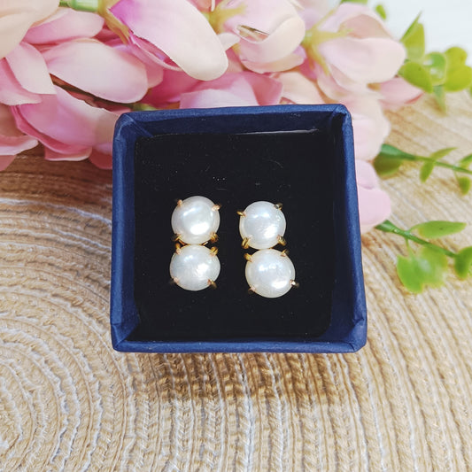 Close-up of gold-plated pearl studs reflecting natural light, 2 line pearl earring