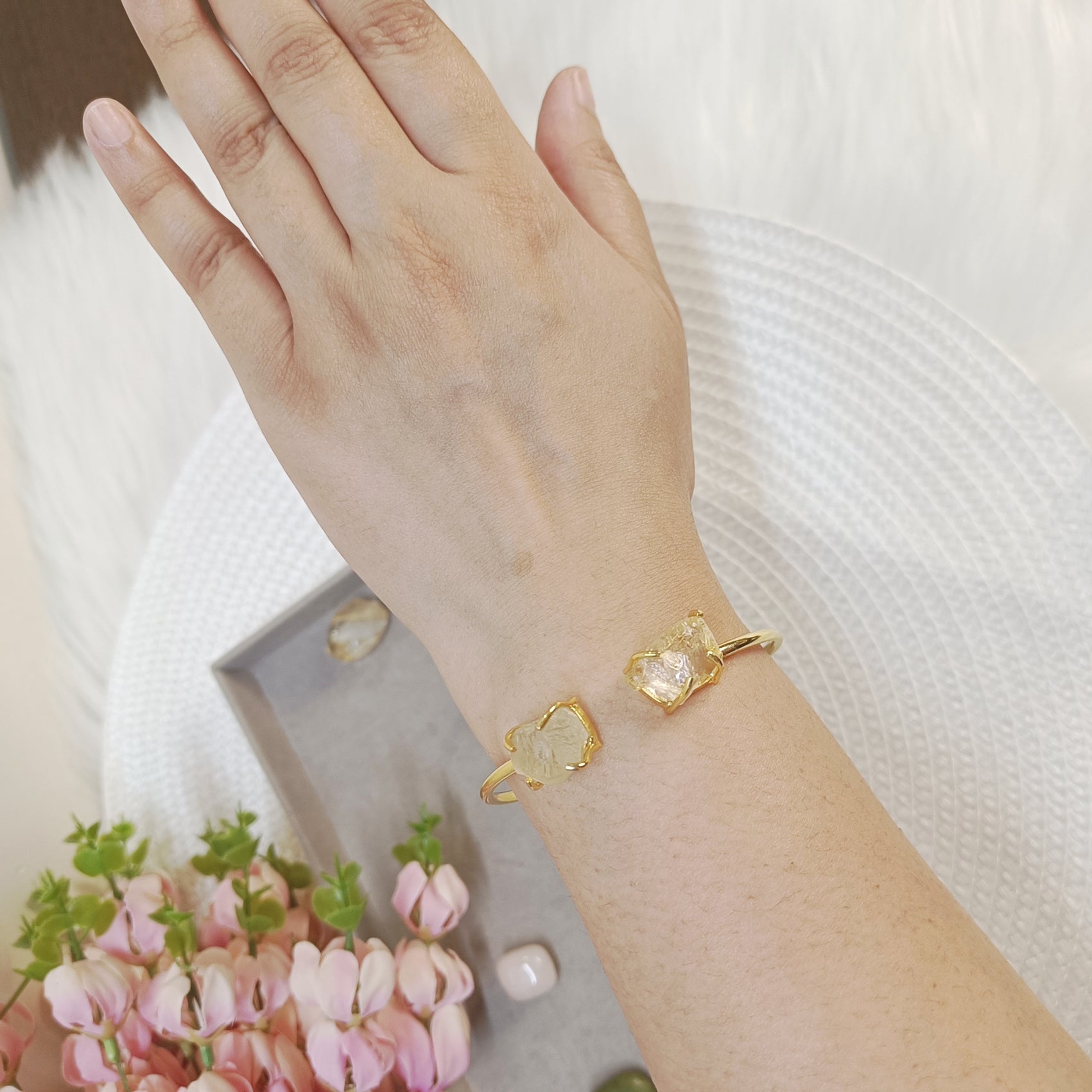 Hand wearing a yellow stone adjustable bangle, hand wearing a citrine cuff bangle