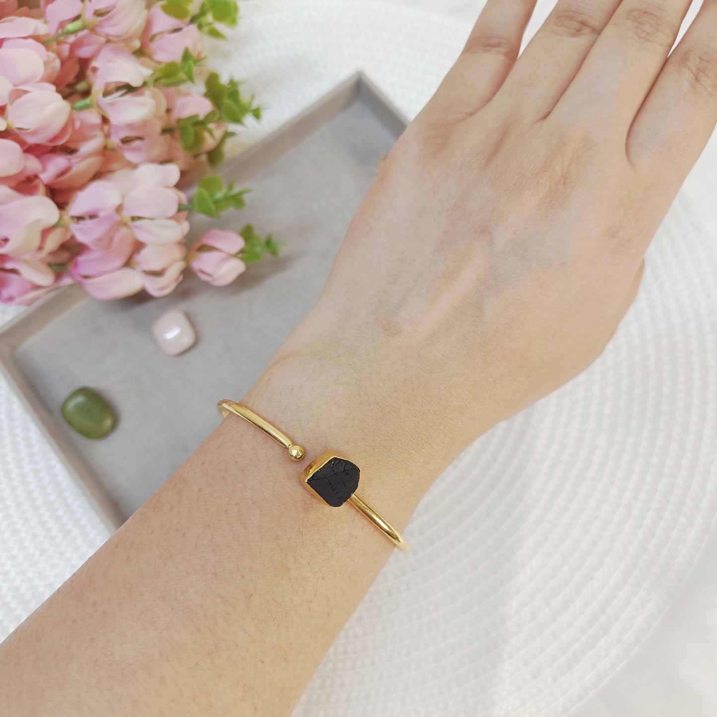 Uncut black Tourmaline brass bracelet with adjustable golden cuff design, handcrafted jewelry.